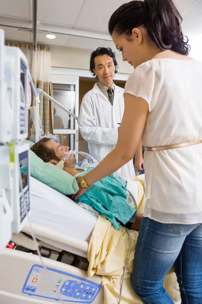 Doctor Looking At Woman Standing By Patient's Bed — Stock Photo, Image