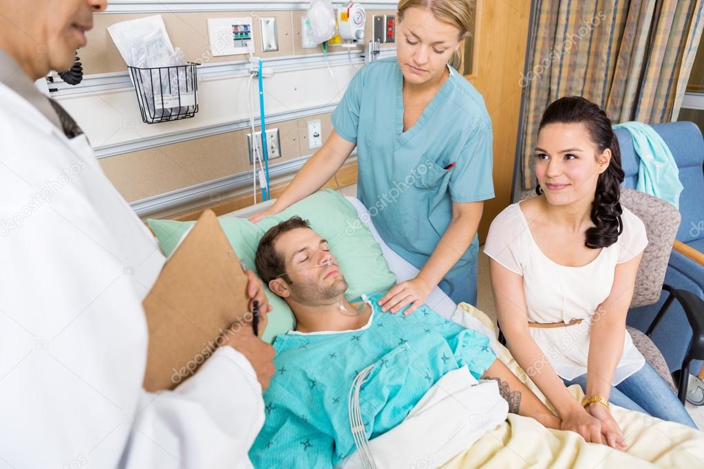 Woman Looking At Doctor While Holding Man's Hand