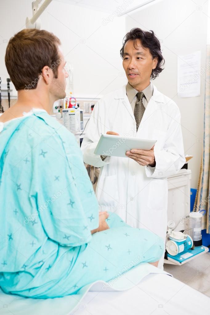 Doctor Discussing Report Over Digital Tablet With Patient
