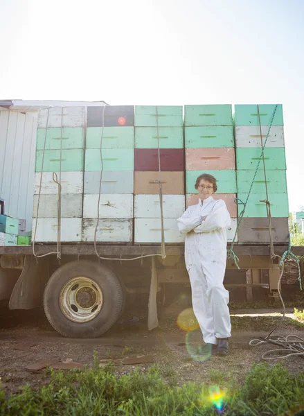 Apiculteur debout contre camion chargé avec des caisses en nid d'abeille — Photo