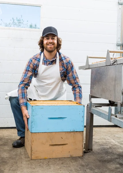 工場でハニカム ボックスと男性の養蜂家 — ストック写真