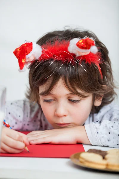 Noel Baba'ya mektup yazma santa bandı giyen çocuk — Stok fotoğraf