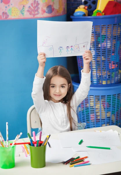 Muchacha mostrando papel de dibujo en clase de arte — Foto de Stock