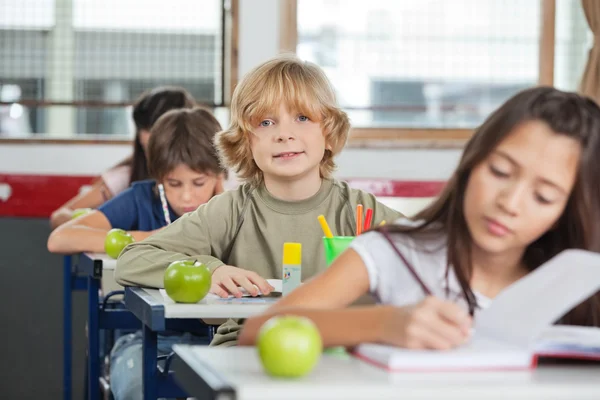 Schoolboy Sitting In A Row With Classmates At Classroom — Stock Photo, Image