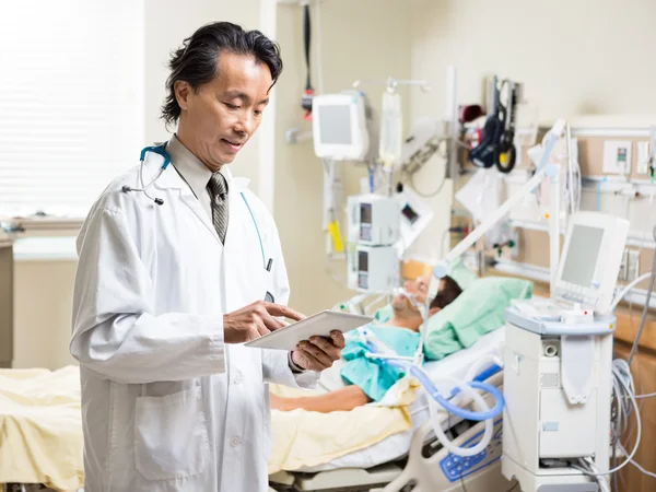 Médecin utilisant la tablette numérique tandis que le patient se repose à l'hôpital — Photo