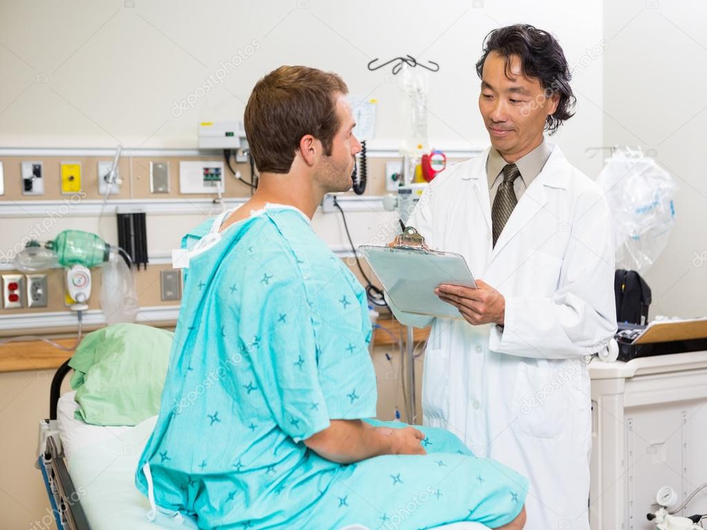 Doctor Examining Patient's Report In Hospital