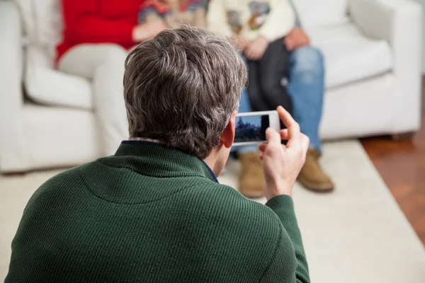 Pai fotografar família através de Smartphone — Fotografia de Stock