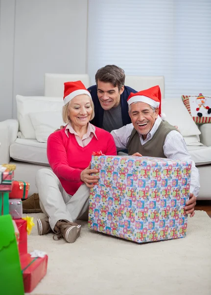 Hombre con padres sosteniendo regalo de Navidad —  Fotos de Stock