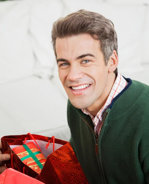 Glücklicher Mann mit Sack voller Weihnachtsgeschenke — Stockfoto