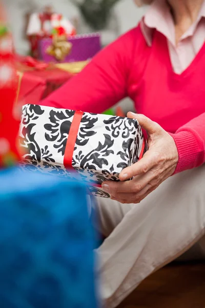 Seniorin mit Weihnachtsgeschenk — Stockfoto
