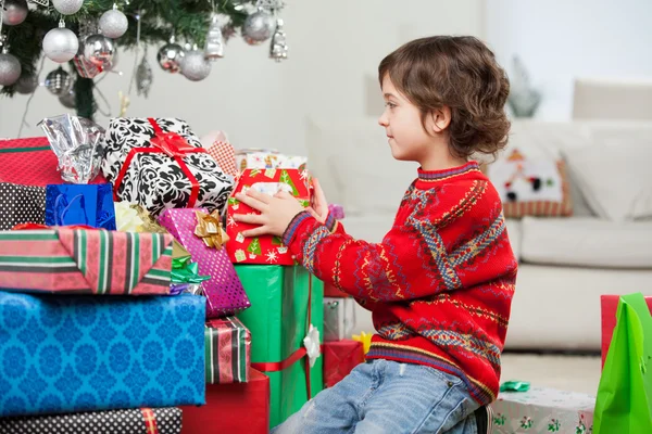 Boy Stacking Christmas Presents Stock Photo