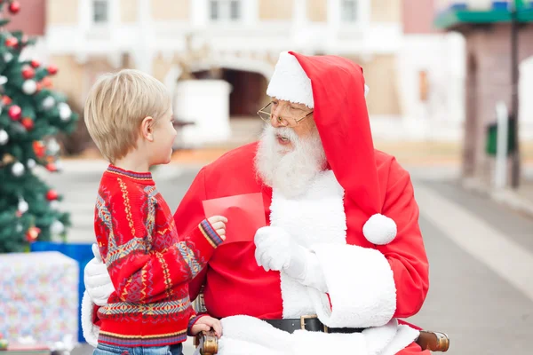 Menino dando lista de desejos para Papai Noel — Fotografia de Stock