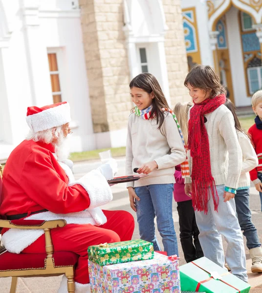Kinder nehmen Kekse vom Weihnachtsmann — Stockfoto
