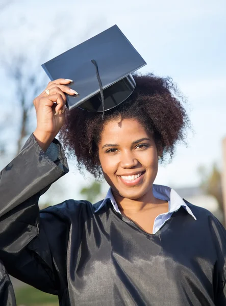 Kvinna i gradering klänning klädd murbruk styrelsen på campus — Stockfoto