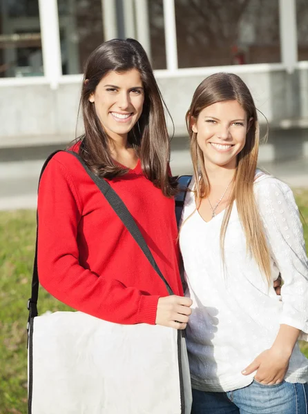 Hermosos amigos sonriendo juntos en el campus universitario —  Fotos de Stock