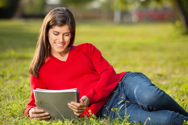Student liest Buch, während er sich auf dem College-Campus entspannt — Stockfoto