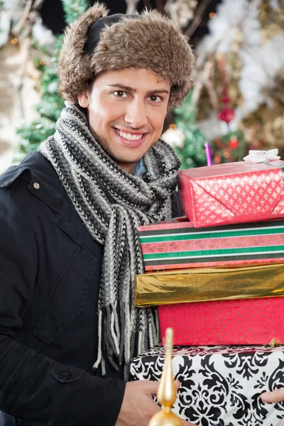 Mutlu bir adam yığılmış taşıyan hediye kutuları — Stok fotoğraf