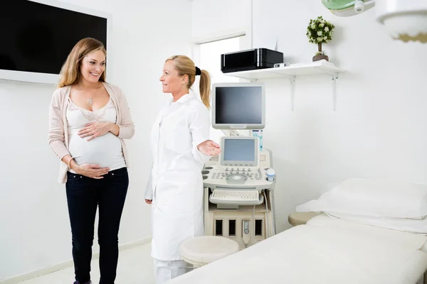 Gynäkologe zeigt Schwangeren Bett — Stockfoto
