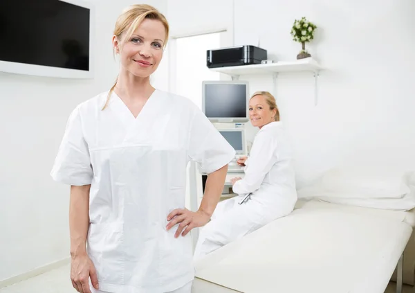 Confident Gynecologist With Colleague In Background — Stock Photo, Image