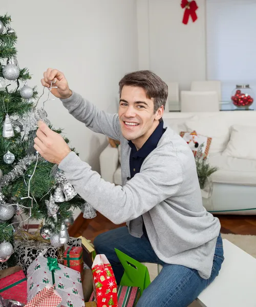 Gelukkig man kerstboom versieren — Stockfoto