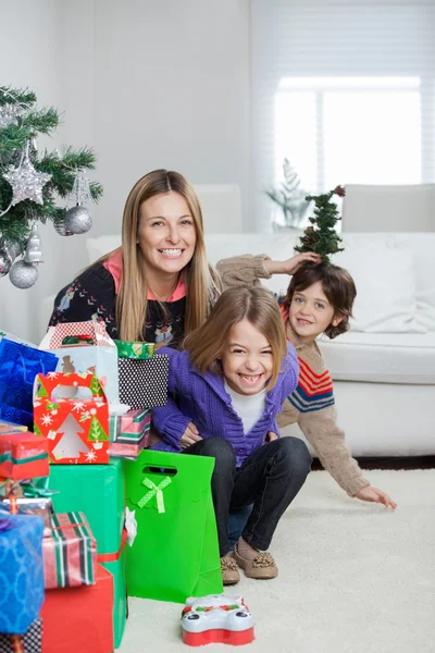 Moeder met kinderen zitten door giften van Kerstmis — Stockfoto