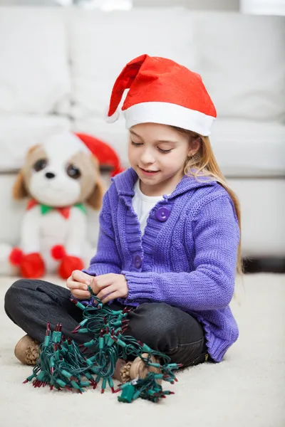 Menina com luzes de fadas durante o Natal — Fotografia de Stock