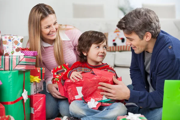 Pais com filho abrindo presente de Natal Fotografia De Stock