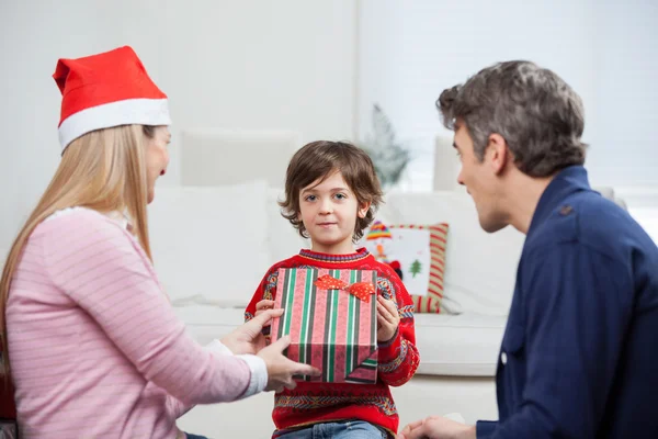 Мальчик забирает подарок от матери на Рождество — стоковое фото