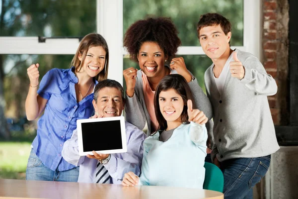 Profesor sosteniendo mesa digital con estudiantes gestos en Classro — Foto de Stock