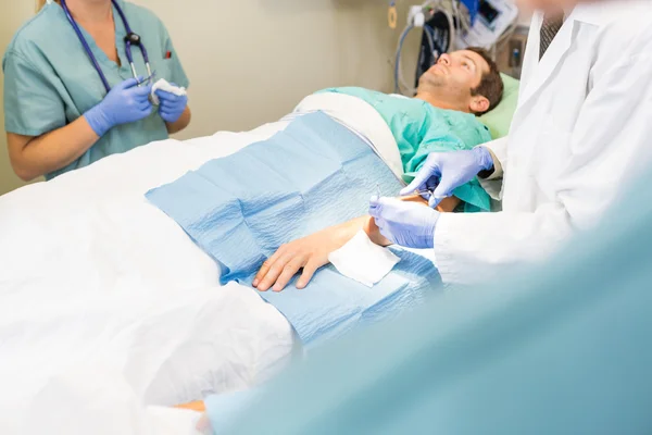 Doctor Stitching Male Patient's Wound — Stock Photo, Image