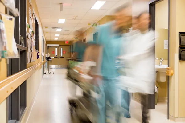 Médecin et infirmière tirant civière à l'hôpital — Photo