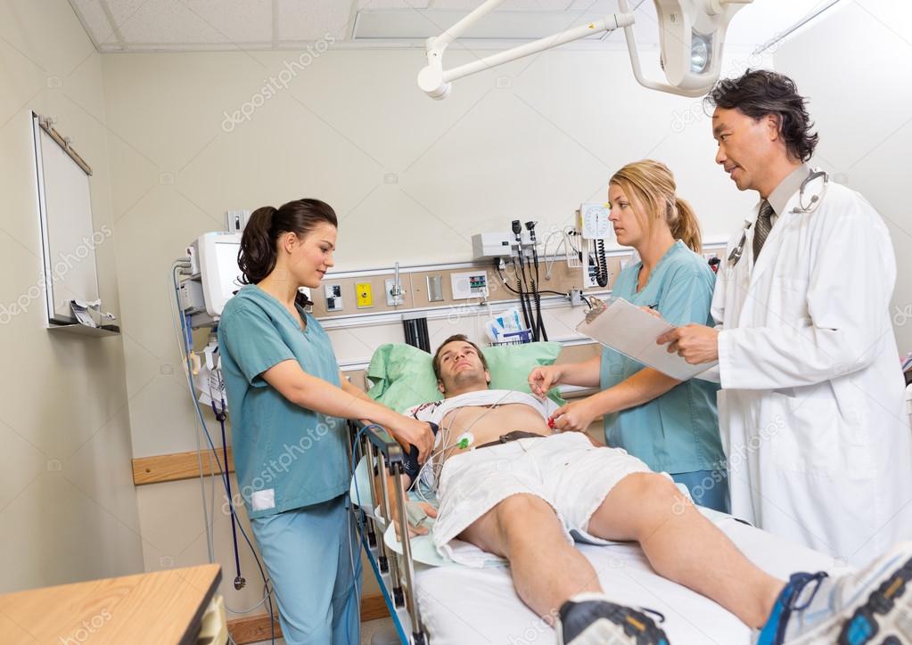 Doctor And Nurses Checking Patient In Hospital