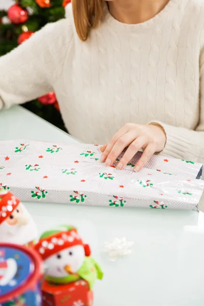 Женщина упаковывает подарок на Рождество — стоковое фото