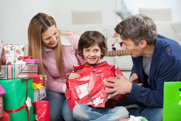 Pojke och föräldrar öppnar julklapp — Stockfoto