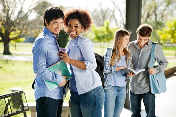 Student tonen cellphone aan vriend op campus — Stockfoto