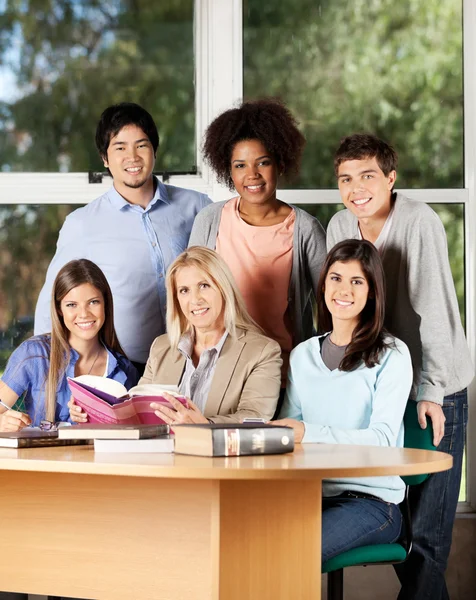 Estudantes universitários e professor com livros na sala de aula — Fotografia de Stock