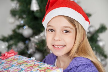 meisje dragen kerstmuts met een gift van Kerstmis
