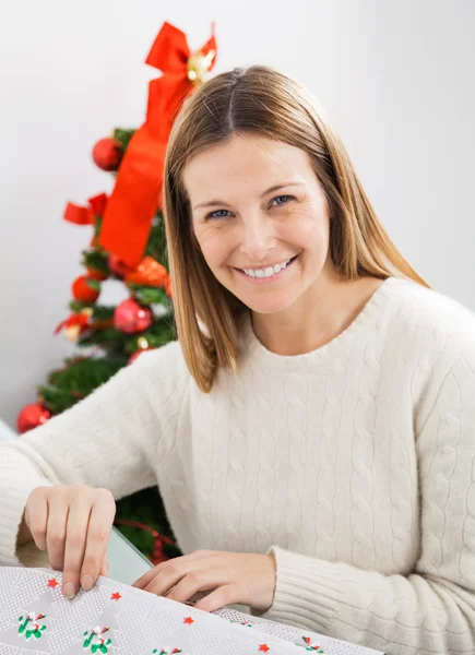 Mujer feliz envolviendo regalo de Navidad —  Fotos de Stock