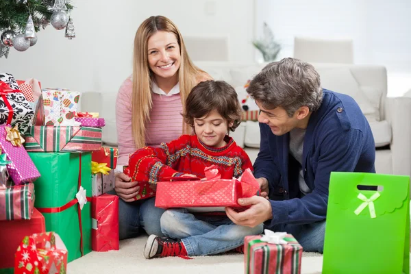 Mulher com menino e homem presente de Natal de abertura — Fotografia de Stock