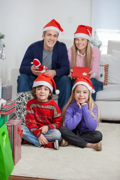 Familie in Weihnachtsmützen zu Hause zu Weihnachten — Stockfoto