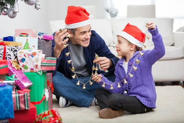 Far och dotter håller christmas ornament — Stockfoto