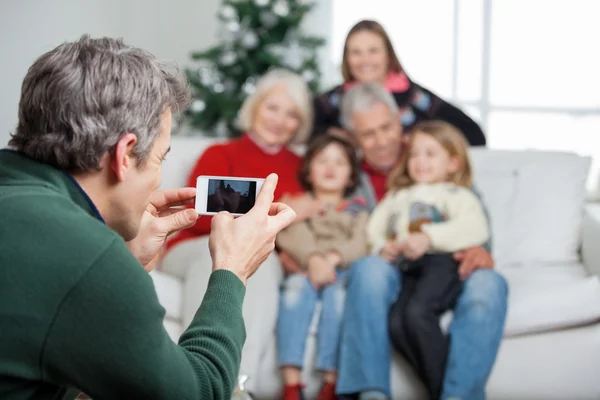 Far fotografera familjen genom smartphone — Stockfoto