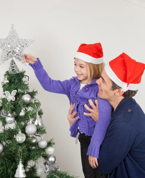 Padre e figlia guardando l'albero di Natale Foto Stock