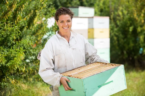 Hembra apicultora llevando jaula de panal — Foto de Stock