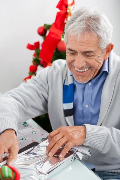 Mann verpackt Weihnachtsgeschenk — Stockfoto