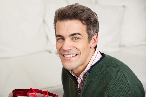 Uomo sorridente a casa durante il Natale — Foto Stock