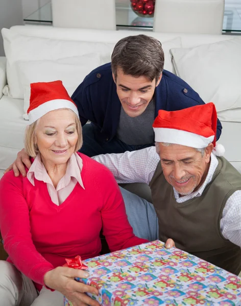 Familia mirando el regalo de Navidad — Foto de Stock