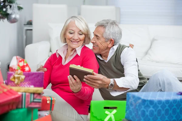 Senior-Mann schenkt Frau ein Weihnachtsgeschenk — Stockfoto