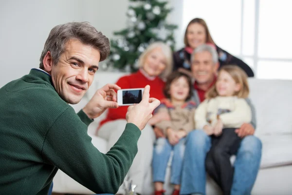 Baba aile mobilephone aracılığıyla Noel sırasında fotoğraf çekmek. — Stok fotoğraf