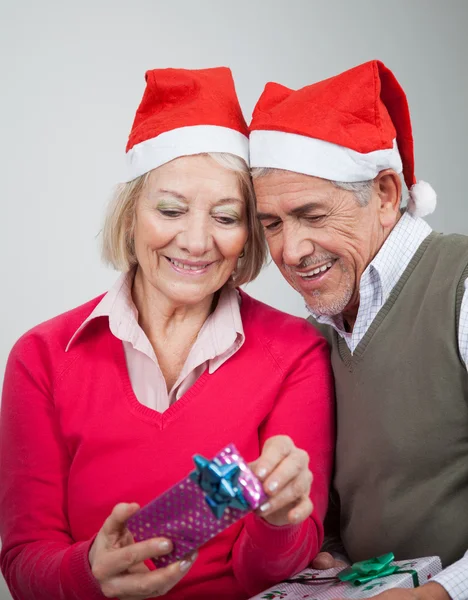 Šťastný starší pár při pohledu na vánoční dárky — Stock fotografie